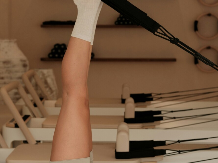 Woman exercising on a Pilates reformer machine